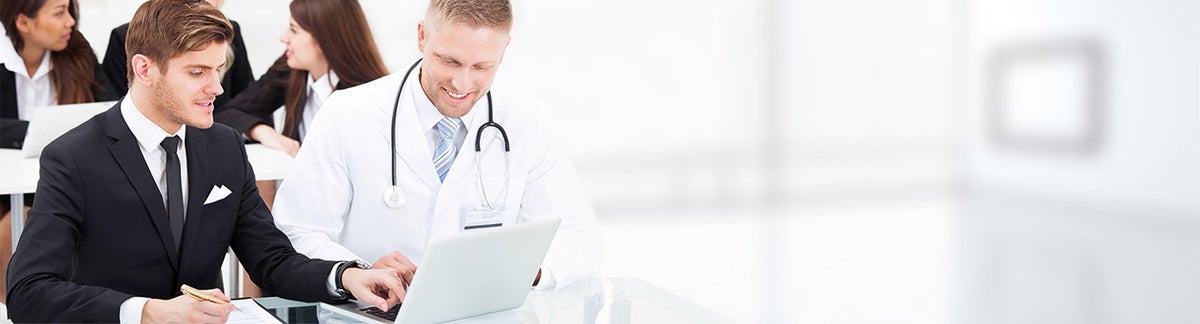 Doctor And Businessman Discussing Over Laptop